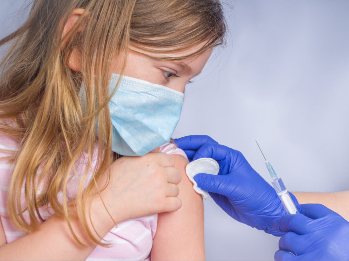Enfermera administra una vacuna a una niña